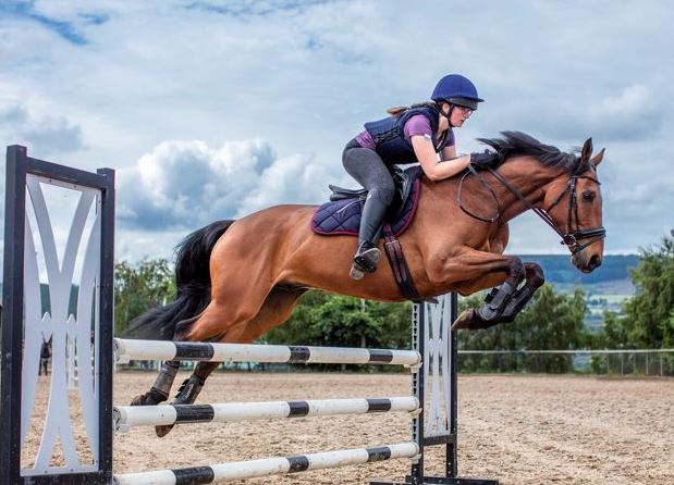 Image of woman jumping horse